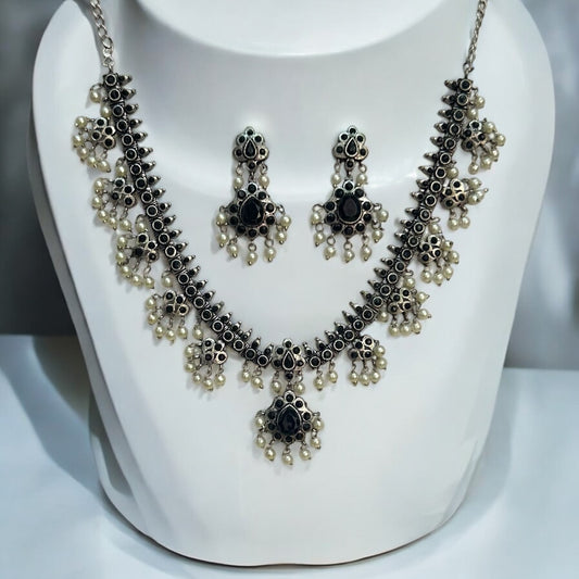 Silver Replica Necklace and Earrings Set with black accents, intricate detailing, and dangling pearl embellishments, displayed on a white bust against a soft background.