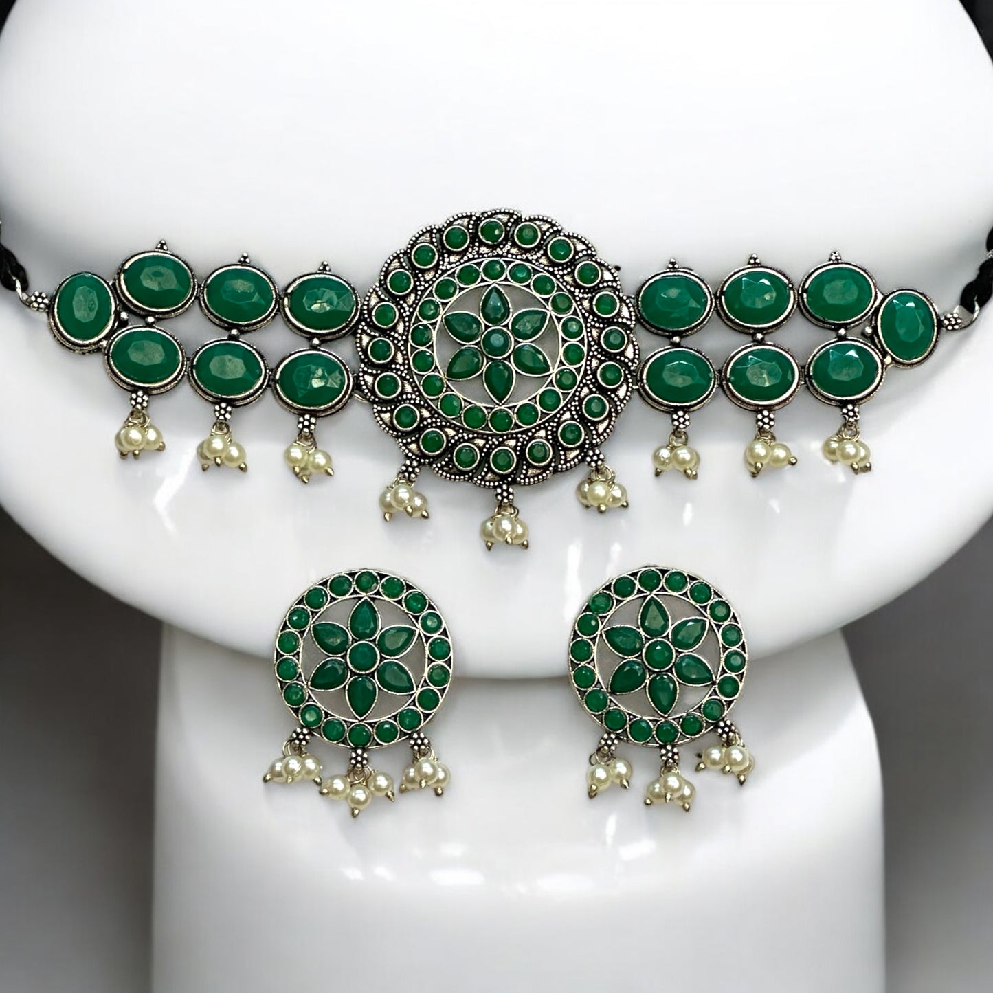 Silver Replica Choker Necklace Set in green color featuring a central circular design with floral patterns, oval green stone embellishments, and dangling pearl accents, displayed on a white Jewellery display stand.