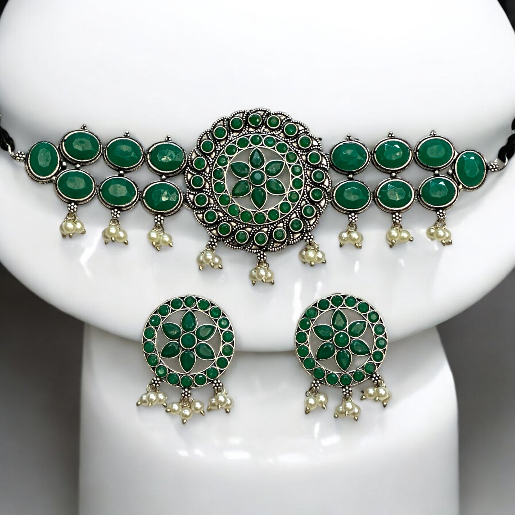 Silver Replica Choker Necklace Set in green color featuring a central circular design with floral patterns, oval green stone embellishments, and dangling pearl accents, displayed on a white Jewellery display stand.