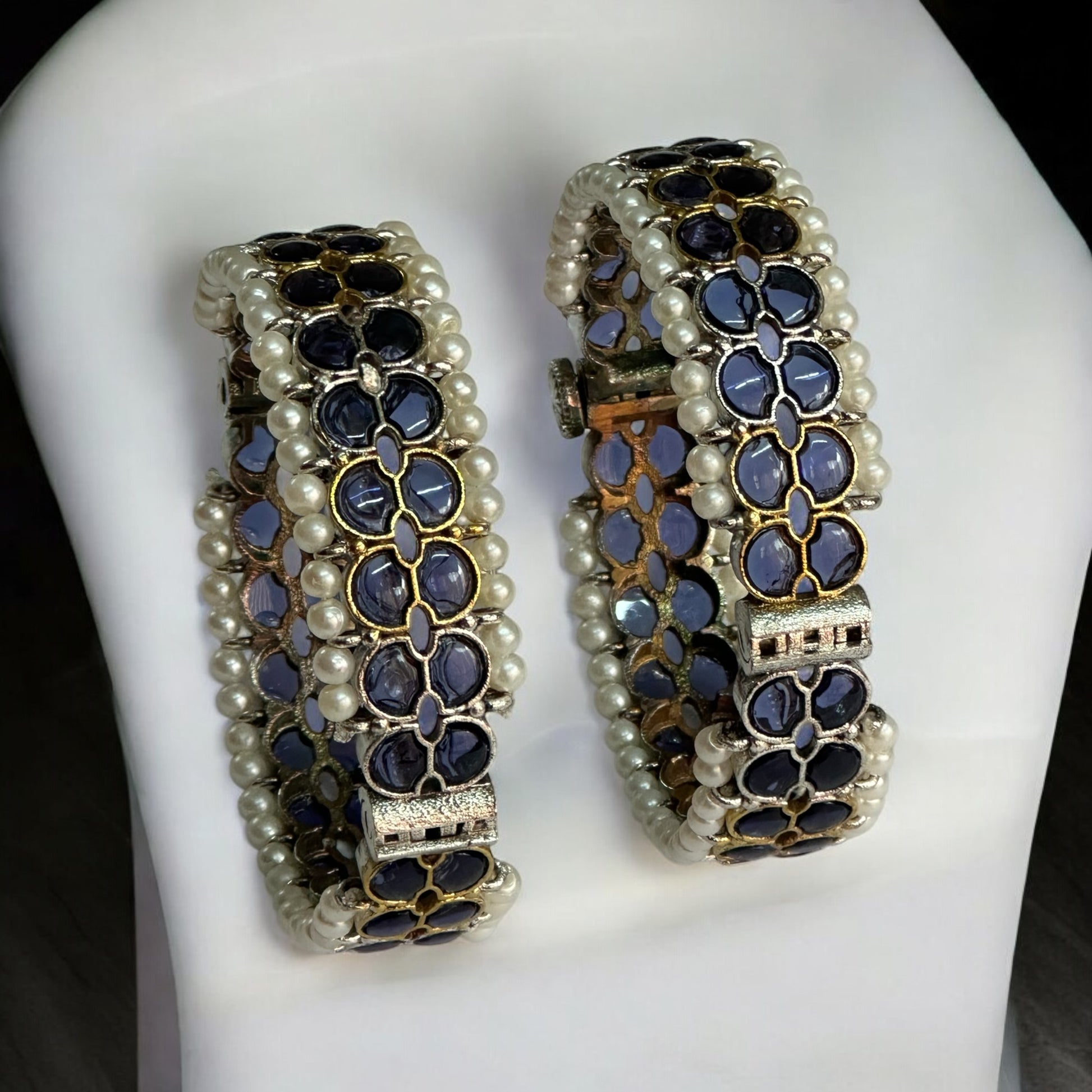 Silver Replica Purple Bangles adorned with white pearls and intricate design, perfect for elegant occasions. Bangles are placed on a white jewellery display stand
