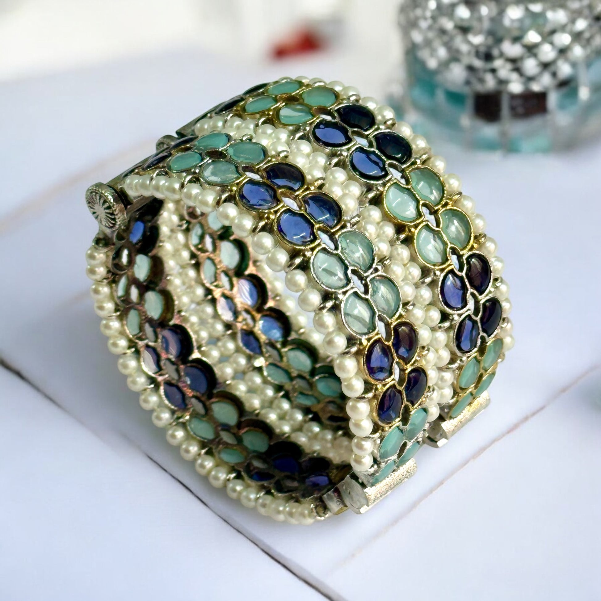 Silver replica bangles with intricate green and blue enamel accents and pearl detailing.