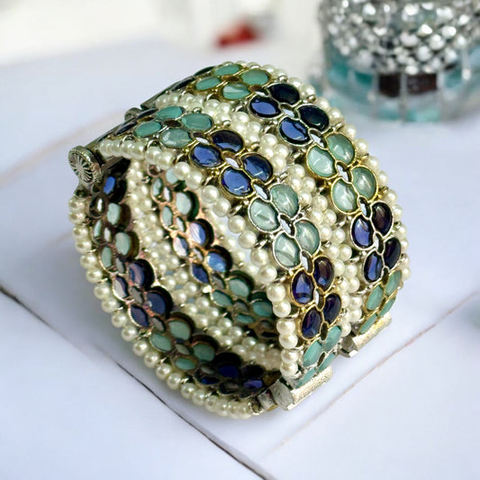 Silver replica bangles with intricate green and blue enamel accents and pearl detailing.