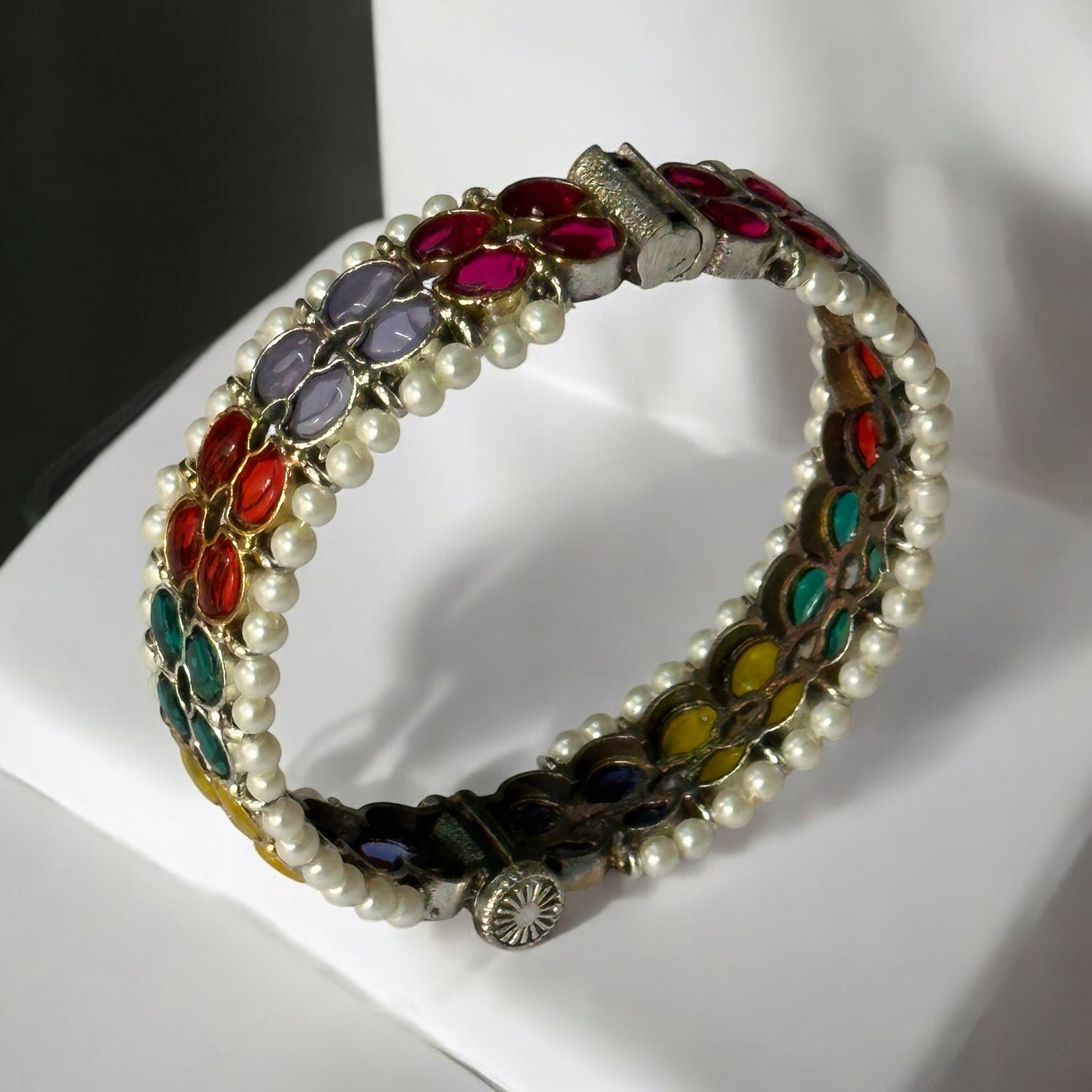 Side view of Silver replica bangle featuring vibrant multicolored enamel floral patterns and delicate pearl accents, displayed on a white background to highlight its intricate craftsmanship.