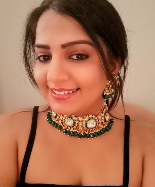 A model displaying polki kundan statement choker necklace set In Green from bella & Diva ltd to be sold in London online.
